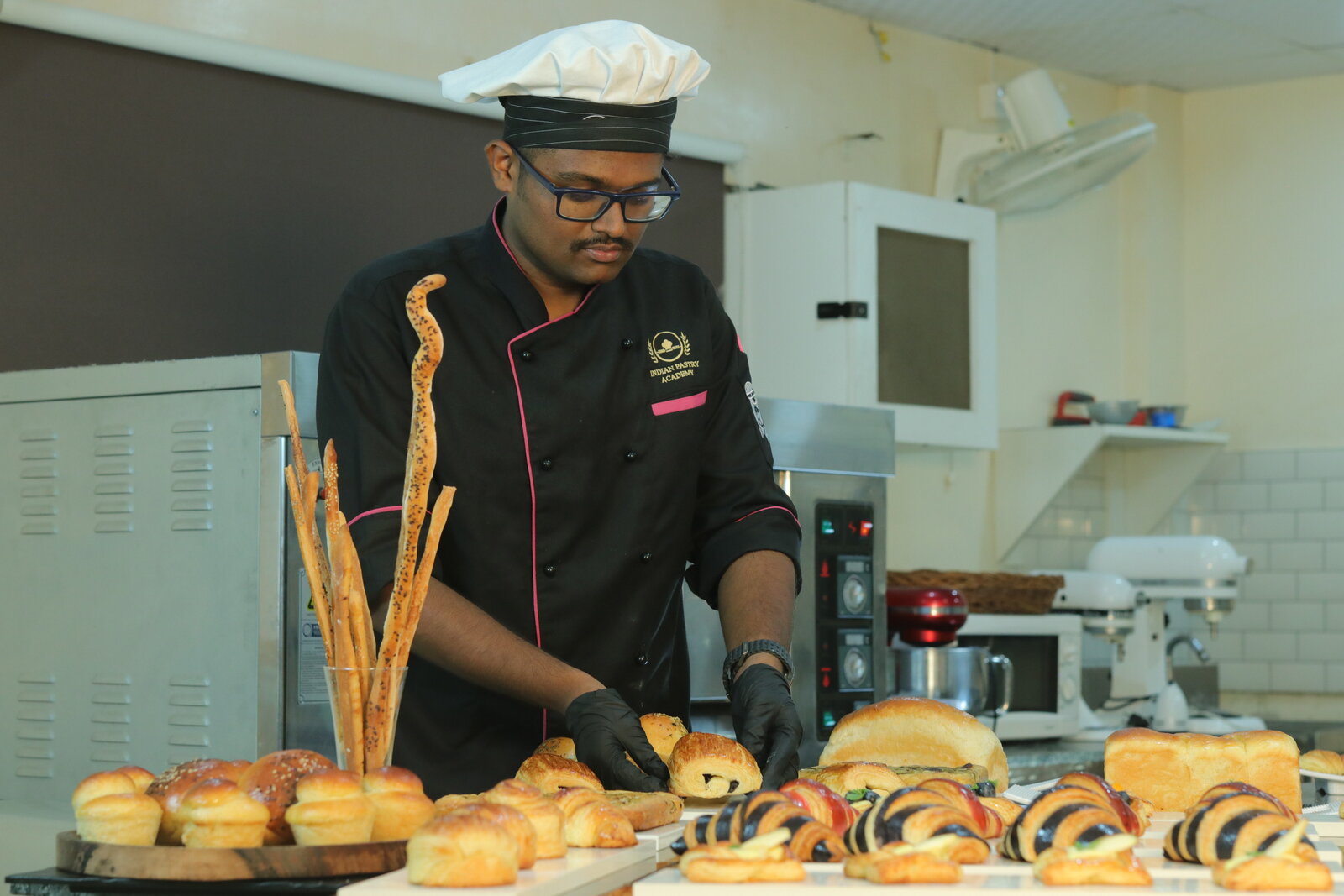 Indian Pastry Academy student arranging a viennoiserie and bread display
